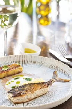 Fine Dining Presentation of Cooked Fish with Crispy Skin and Creamy Sauce.. Stock Photos