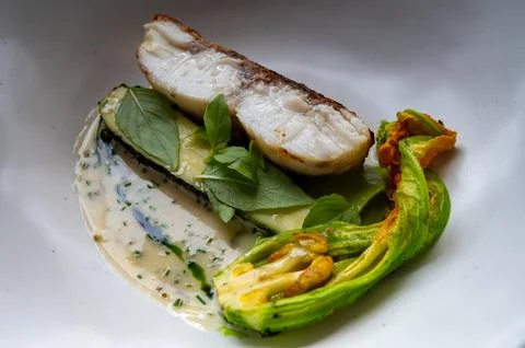Fine dining in restaurant with chef, main  dish with white fish, young zucc.. Stock Photos
