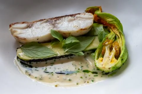 Fine dining in restaurant with chef, main  dish with white fish, young zucc.. Stock Photos