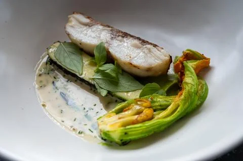Fine dining in restaurant with chef, main  dish with white fish, young zucc.. Stock Photos