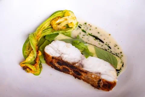 Fine dining in restaurant with chef, main  dish with white fish, young zucc.. Stock Photos