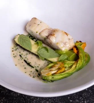 Fine dining in restaurant with chef, main  dish with white fish, young zucc.. Stock Photos