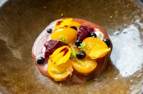 Fine dining in restaurant with chef, starter vegetarian dish fresh ripe gar.. 库存照片
