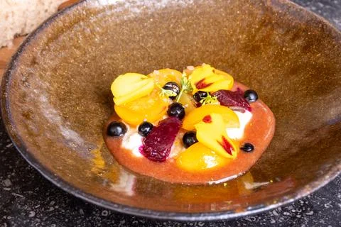 Fine dining in restaurant with chef, starter vegetarian dish fresh ripe gar.. 库存照片