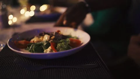 Fine Dining Service: Elegant Senegalese Waiter Serving Gourmet Steak Dish to Hap Stock Footage 309913854