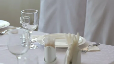 Fine dining table setting in restaurant with plates cutlery and stemware Stock Footage 89789125