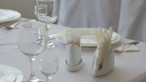 Fine dining table setting in restaurant with plates cutlery and stemware Stock Footage