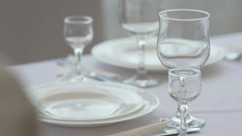 Fine dining table setting in restaurant with plates cutlery and stemware Stock Footage 90070798