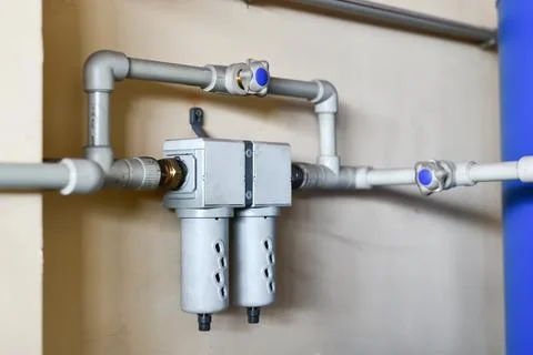 The fine filter of water supply is fed into one system, fixed on the wall. Stock Photos