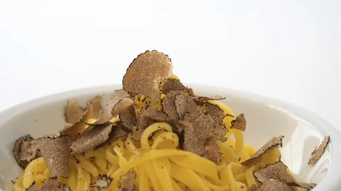 Fine grated black truffle falling on a plate of Italian fettuccine. Slow motion Stock Footage 92934687