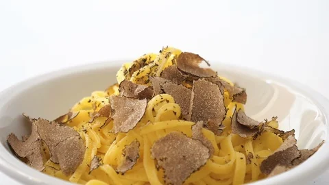 Fine grated black truffle falling on a plate of Italian fettuccine. Slow motion Stock Footage 92934747