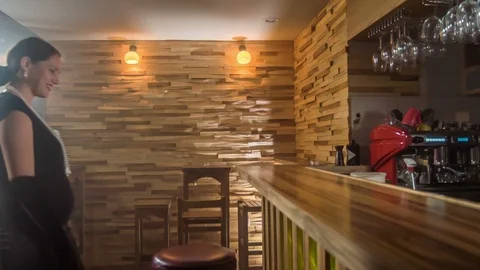 Fine lady sits down at a counter bar and orders a drink Stock Footage 112192298