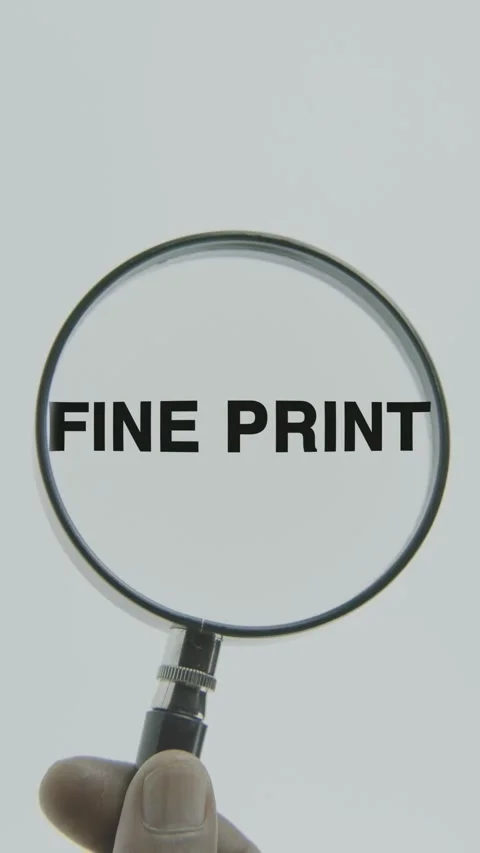 Fine Print text or word highlighted by a magnifying glass in a hand Stock Footage 303447135