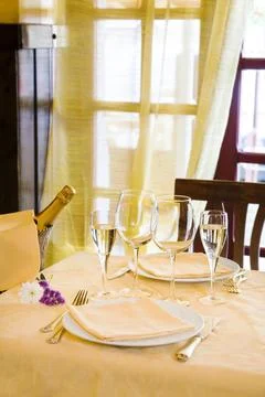 Fine restaurant table setting and champagne bottle Stock Photos