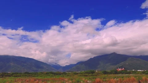 In fine weather, billowing clouds fly over the mountain and valley city. Video stock 277945353