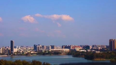 In fine weather, billowing clouds fly over the lake and city. Stock Footage 280138238