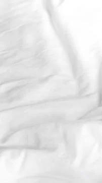 Fine white fabric surface featuring subtle texture and soft natural folds. Stock Photos