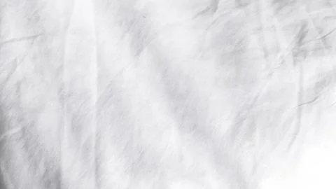 Fine white fabric surface featuring subtle texture and soft natural folds. Stock Photos