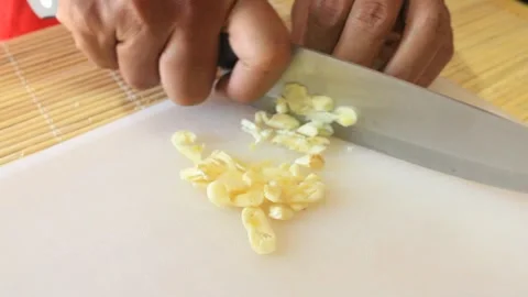 Finely chop the garlic. prepare cooking ingredients Stock Footage 334647347