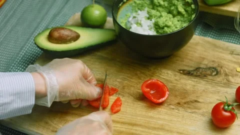 Finely chop the tomato for the Guacamole Stock Footage 169350355