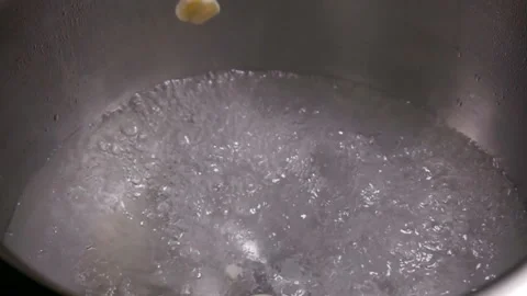 Finely chopped garlic falls into the boiling water Stock Footage 113912834
