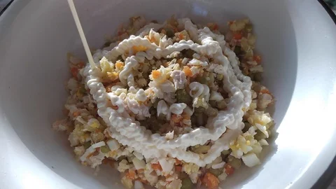 Finely chopped vegetables and meat are mixed in a plate. mayonnaise in a salad. Stock Footage 121004534