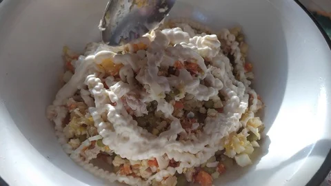 Finely chopped vegetables and meat are mixed in a plate. mayonnaise in a salad. Stock Footage 121004578