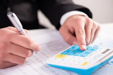 A finger adding up figures using a calculator Stock Photos