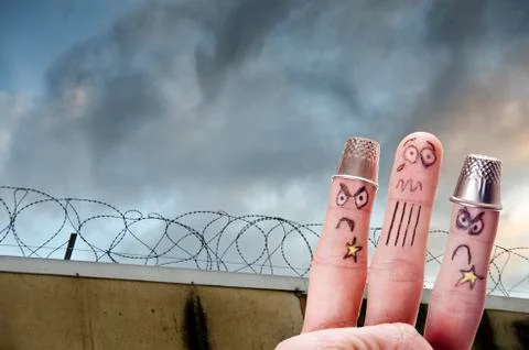 Finger is captive with prison wall in background Stock-Fotos