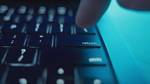 Finger clicking on Return or Enter key on laptop keyboard at night in dark room Stock Footage 340234118