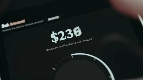 Finger drags the arrow around the dial to set the amount for payment Stock Footage 332497613