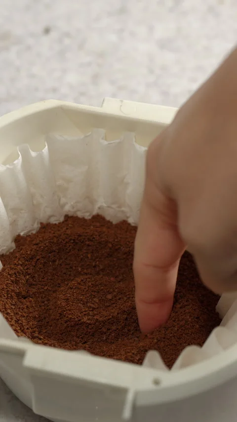 Finger drawing a “C” on ground coffee in a paper filter Stock Footage 311902774