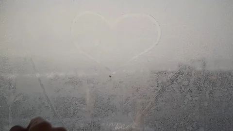 Finger draws heart at a window 库存影片 75685560