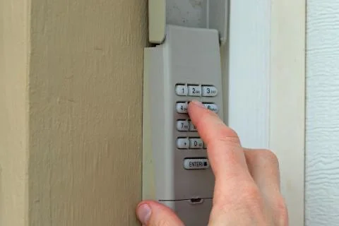 Finger entering code on keypad - garage door opener - home security Stock Photos