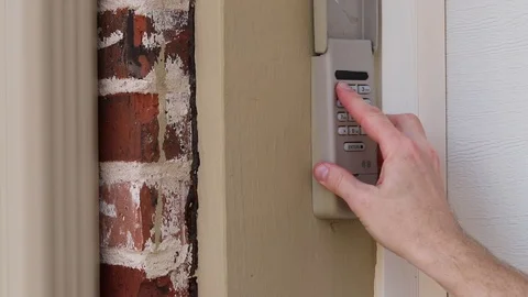 Finger enters code on Keypad used on a garage door entrance to a home - security Video stock 102726638