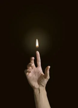 A finger holding a flame. Stock Photos