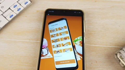 Finger installing JUST EAT app on the phone Stock Footage 144121064