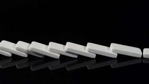 Finger Makes Dominoes Fall on a black table Stock Footage 243346265