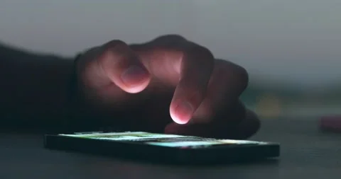 Finger of man touching scroll page app on mobile phone at night. Hands of person Stock Footage 238679869