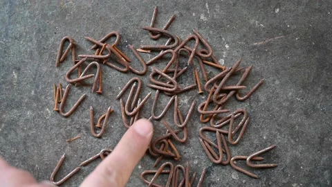Finger moving counting rusty nails on grey background Stock Footage 152338982