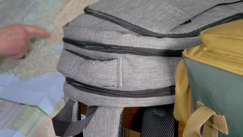 Finger navigating a map with backpacks in the foreground. Video stock 146130170