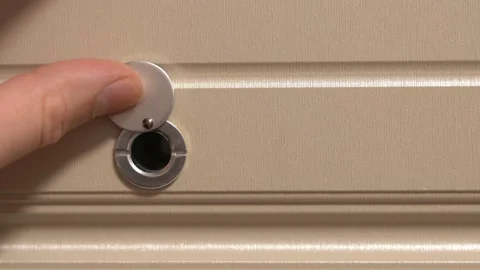 A finger opens a peephole in a close-up. Unexpected guests. Vídeos de archivo 154185004
