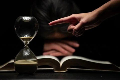 Finger of Person Pointing to Time while Woman Sleeps Over Bible Stock Photos