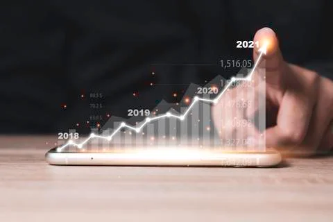 Finger point to increase virtual arrow of investment graph on mobile phone. Stock Photos