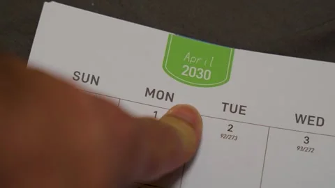 Finger pointing at April 2030 planner page close up for future scheduling and Stock Footage 336486249