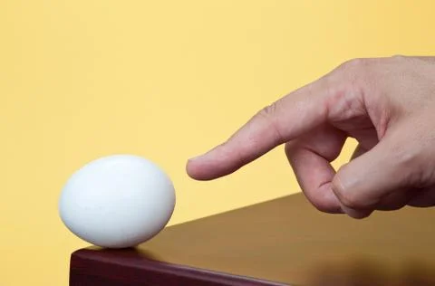 Finger pointing to an egg Stock Photos