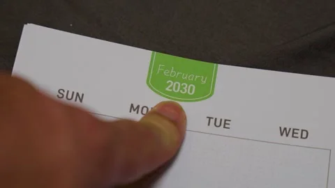 Finger pointing at February 2030 planner page close up for future scheduling and Stock Footage 336486337