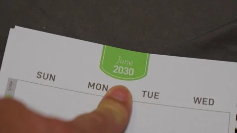 Finger pointing at June 2030 planner page close up for future scheduling and Stock Footage 336486055