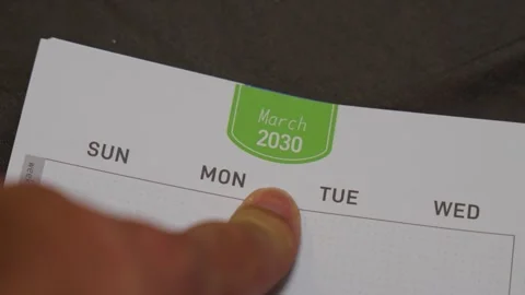 Finger pointing at March 2030 planner page close up for future scheduling and Stock Footage 336486288