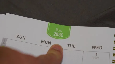 Finger pointing at May 2030 planner page close up for future scheduling and Stock Footage 336486211